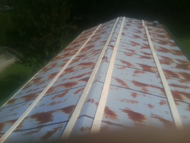 Rusted metal roof panels with new wood purlins before replacement — Storm Damage Roof Repair in Burnett by Roofing Brothers