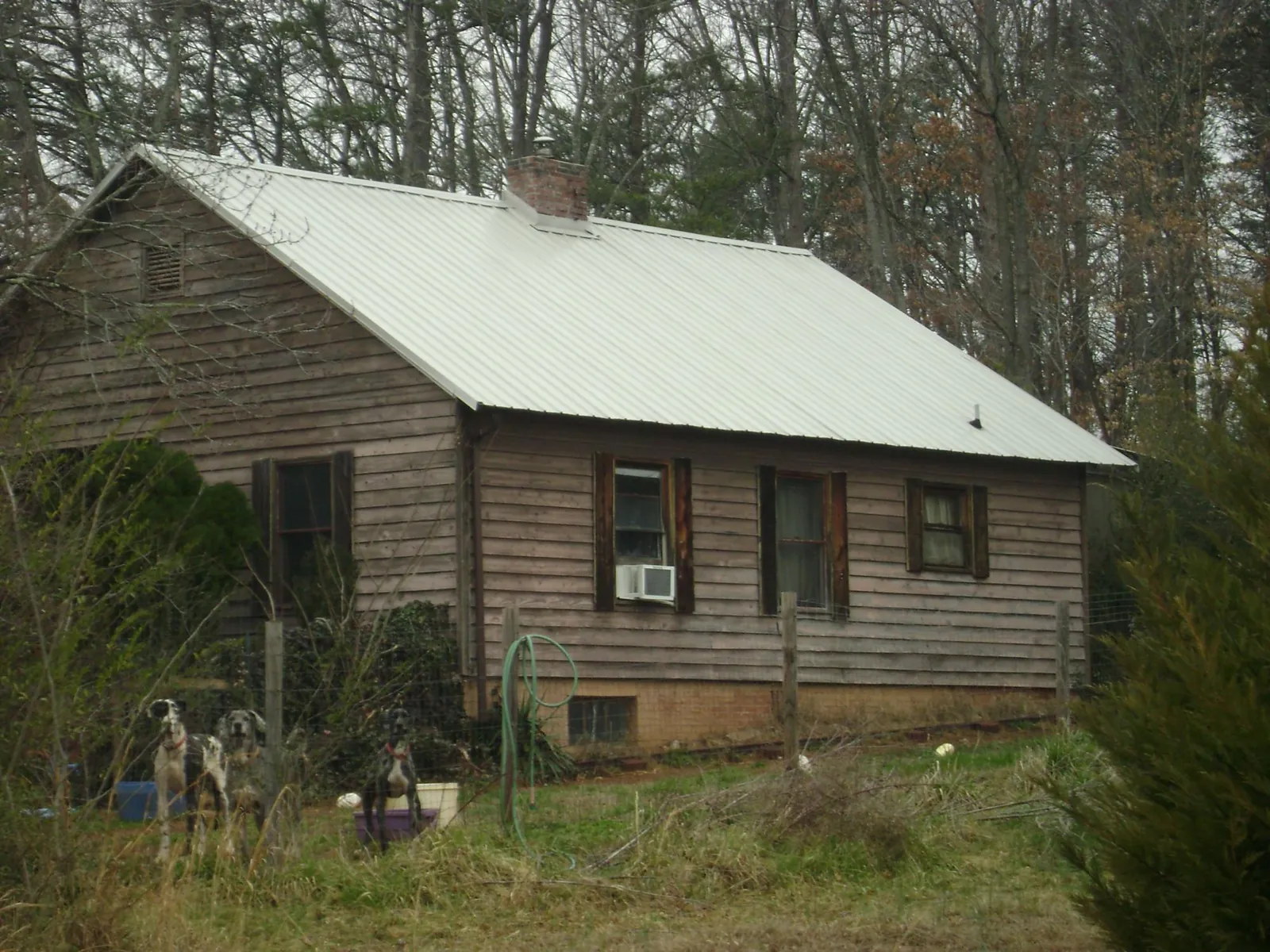 White metal roof on an old wood sided farmhouse, from a Metal Roof Installation job in Burnett